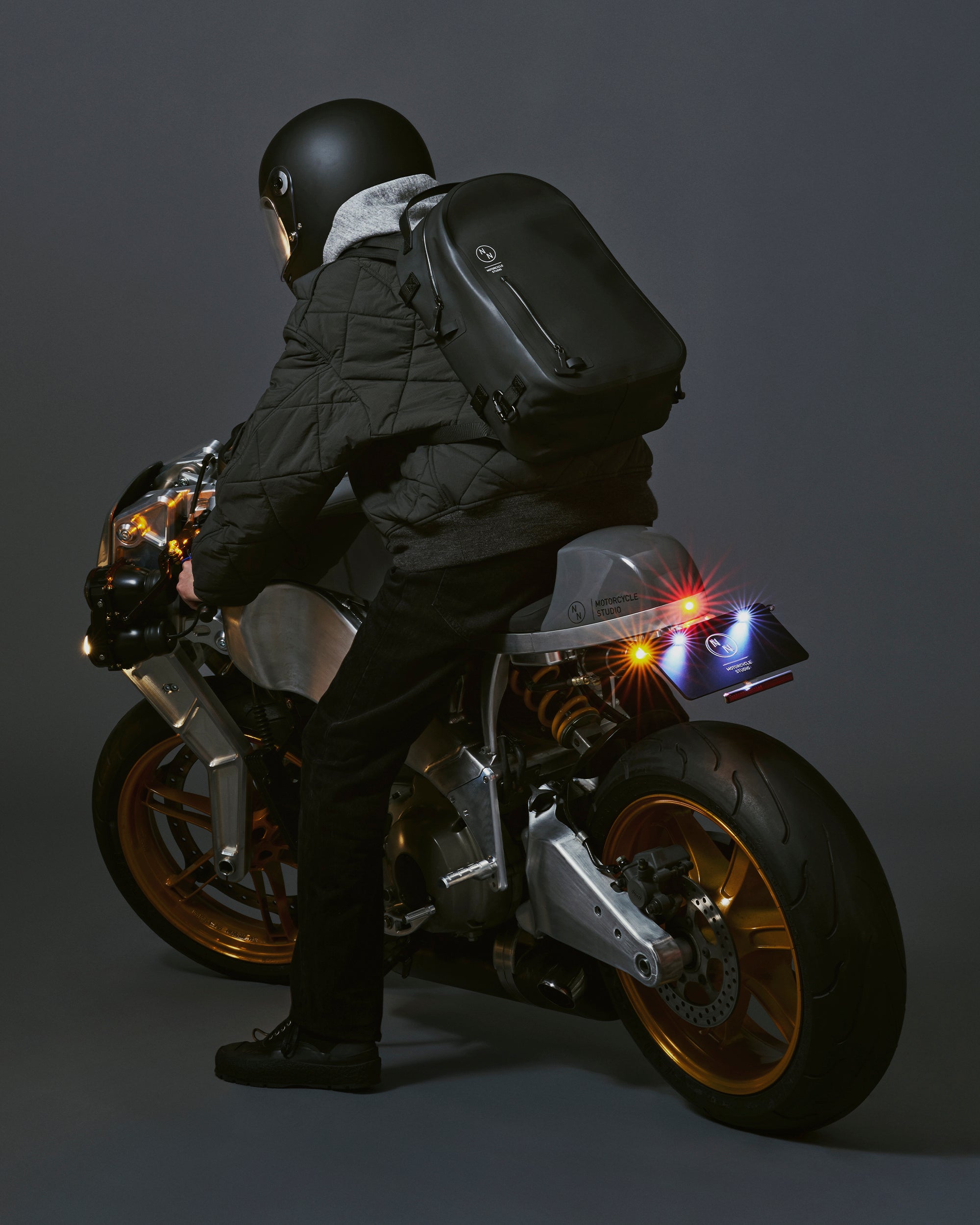 防水リュックを背負ってBuellのバイクに乗っているシーン